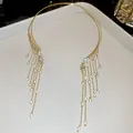 Nahaufnahme des eleganten Angel Wings Gold-Chokers mit funkelnden Kristallquasten - Engelsflügel-Quasten-Stil / Gold