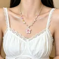Detalle de un collar de cuentas colorido con un colgante de flor rosa en una modelo. - Púrpura (HN12248)