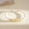 Primo piano di un bracciale rigido in argento con cristallo grezzo giallo avvolto - Montatura Argento con Pietra Gialla / Argento-Giallo