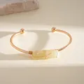 Dettaglio di un bracciale rigido in oro rosa con una pietra di cristallo gialla - Montatura Oro con Pietra Gialla / Oro-Giallo