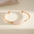 Dettaglio di un bracciale rigido dorato con cristallo rosa e finitura elegante - Montatura Oro con Pietra Rosa / Oro-Rosa