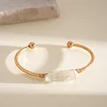 Primo piano dettagliato di un bracciale a fascia dorato con cristallo. - Oro-Bianco