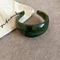 Detailed view of vintage green acrylic cuff bracelet with irregular marbled texture - Dark Green
