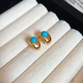 Primo piano di orecchini vintage dorati con pietra turchese in un vassoio portagioie - 11# Perno in argento - Oro-Blu
