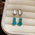 Dettaglio di orecchini vintage con perle turchesi e intarsio in conchiglia in un portagioie - Stile 21# Perno in Argento-Oro-Blu