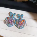 Vista dettagliata di orecchini a cuore vintage con strass rosa e accenti di fiocco blu - Ago D'argento N. 25 - Argento - Blu - Rosa