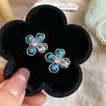 Dettaglio di orecchini a fiore turchesi con cristalli in un vassoio di velluto nero - 27# Perno in argento-Argento-Blu