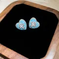 Primo piano di orecchini a cuore con intarsi in turchese e croce in pavé di pietre. - Ago Argentato N. 28 - Argento - Blu - Grande
