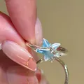 Detailansicht eines silbernen Seestern-Rings mit blauer Emaille und funkelnden Steinen - Sternstrahl-Design (29#) / Silber Blau