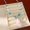 Gedetailleerde weergave van oceaan-ketting met schelpen, zeesterren en kralen - Wulk Zeester Stijl (HN12165) / Blauw/Wit
