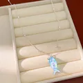 Detail van een zilveren ketting met een prachtige blauw iriserende visvormige hanger. - Hars Vis Stijl (HN12167) / Blauw/Zilver