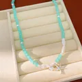 Detailweergave van mintgroene kralenketting met zilveren zeester en schelp bedeltjes. - Gekraalde Zeester Stijl (HN12166) / Blauw/Zilver