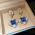 Vintage cameo earrings featuring a large blue gemstone and opal-like details in gold - Blue Gold Portrait Relief Style (HE13834)