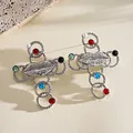 Close-up of retro metallic lip cross earrings with colorful resin stones and pearls - Stud Earrings / Silver