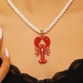 Detailed close-up of a vibrant red enamel lobster pendant necklace with a white rope chain - Red Lobster Pendant White Rope Chain (6308) / Gold