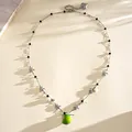Detailed view of a sweet enamel apple necklace featuring silver stars and pearls. - Necklace - Silver - Green