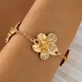 Close-up macro view of a vintage golden floral anklet charm featuring delicate link chain detail. - Golden Multi-Flower Anklet (29834-bra-G)