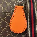 Mini orange leather baseball keychain with red hand-stitching, perfect as a stylish bag charm. - Softball Orange