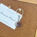 Gros plan d'un porte-cl s en mtal argent avec pendentif rotatif en forme de rugby - Ballon de Rugby Rotatif