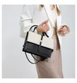 Close-up of an elegant black and woven cream color-block crossbody bag for women - Black