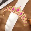 Goldene Brautkrone mit rosa Tropfenkristallen und kleinen Diamanten auf weißem Display - Gold und Rosenrot