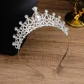 Sparkling silver bridal crown with crystals and side combs on a wooden surface - Style 12 Silver White