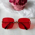 Lunettes de soleil carrées sans monture avec verres rouges et pont en métal doré. - Style Grande Monture Irrégulière Métal Doré Verres Rouges
