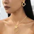 Detail view of a 18K gold geometric jewelry set featuring a necklace and drop earrings - Rhombus Frame Style - Gold