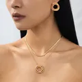 Close-up of elegant double-layer gold snake chain necklace and matching hoop earrings - Triple Intertwined Rings Style - Gold