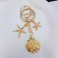 Golden ocean-style keychain featuring pearl-inlaid seashell and starfish charms. - Golden Pearl Starfish (Q1524)
