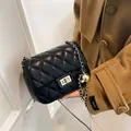 Black quilted crossbody bag with gold chain strap and spherical metal buckle detail - Black
