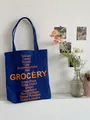 Blaue Stofftasche aus Segeltuch mit orangem Grocery-Schriftzug im trendigen Retro-Stil - Marineblau