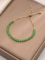 Detail of adjustable gold bracelet with marquise-cut green zircons on silk background - Green