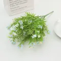 Close-up of faux jasmine and daisy bouquet with blue and white petals and green leaves - Blue