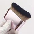 Close-up of a wide flat tanning brush with dense soft bristles and metallic pink handle. - Pink Rose Gold