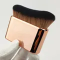 Detailed close-up of a wide body tanning brush with elegant rose gold handle finish. - Rose Gold