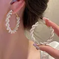 Close-up of large twisted hoop earrings adorned with white pearls on a gold frame - Twisted Artificial Pearl Hoop (E2544 Gold) / 925 Silver Needle / Gold