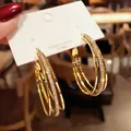 Macro detail view of luxury gold triple hoop earrings with pavé-set cubic zirconia - Gold Triple Intertwined Zirconia (E2595 Gold) / 925 Silver Needle / Gold