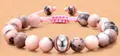 Adjustable pink zebra stone braided bracelet with a silver baseball charm detail - Baseball Braided Style
