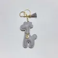 Close-up of grey leather giraffe keychain with gold tassel and rhinestone charm - With Keychain Tassel / Gray
