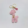 Detail view of a pink cartoon giraffe leather keychain with a tassel accessory - With Keychain Tassel / Pink