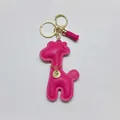 Close-up of a pink giraffe PU leather keychain with a gold clasp and tassel detail - With Keychain Tassel / Rose Red