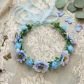 Detailed macro view of a bohemian floral crown with blue and purple silk flowers - Blue