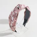 Fashionable wide knotted headband featuring a white floral pattern on dusty pink fabric - Deep Nude Floral Print