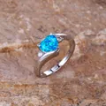 Elegant silver-colored ring featuring a blue heart-shaped opal with zircon accents - US 7 / Silver Tone Blue Synthetic Opal