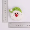 Handmade crochet Santa Claus head charm with green hat shown with size measurement rulers - Finished Santa Claus Head - Light Green