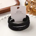 Set of 4 high-elastic black wound hair ties displayed on a white MUJU brand card - 11# Wrapped Cord Black (Pack of 4)