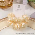 Zwei beige Satin-Haargummis mit Spitzenbesatz auf einer Produktkarte präsentiert - 2er Pack / Beige