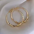 Fashionable gold-toned large hoop earrings with elegant twisted design for women - Spiral Twisted Hoop / Gold