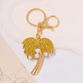 Close-up detail of a golden palm tree keychain with yellow rhinestones and pearls - Gold Coconut Tree With Yellow Rhinestone